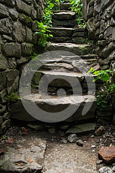 Old narrow stone stairs with brick wall. Explore concept