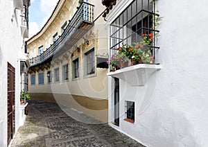 Old narrow street with beautiful balconies decorated with flower pots at traditional Spanish Village & x28;Poble Espanyol& x29;