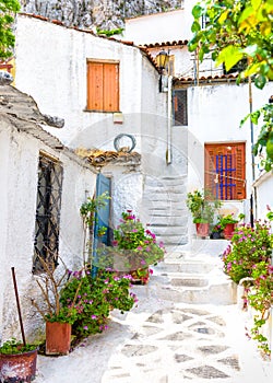 Old narrow street with flowers in Anafiotika, Plaka district, Athens, Greece. Plaka is tourist attraction of Athens