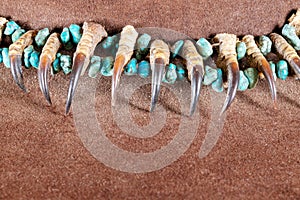 Old Native American Lakota necklace made of raptor claws and turquoise stones on brown felt