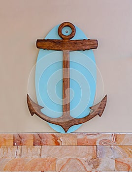 Old nautical wooden anchor on wooden board hanging on the wall