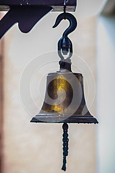 Old naval brass bell. Vintage metal ship`s bell with a rope. Nautical copper ship bell with rope.