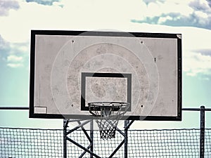 Old neglect backboard with rusty hoop above court