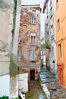 The narrow lane between shabby houses in old Bastia, France