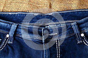 Old or new Blue jeans fashion design On brown hemp sack texture background