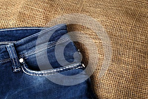 Old or new Blue jeans fashion design On brown hemp sack texture background