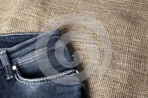 Old or new Blue jeans fashion design On brown hemp sack texture background