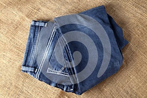 Old or new Blue jeans fashion design On brown hemp sack texture background