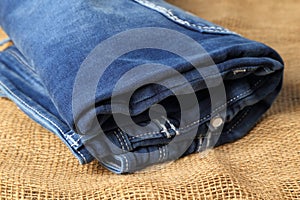 Old or new Blue jeans fashion design On brown hemp sack texture background