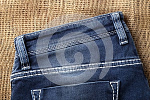 Old or new Blue jeans fashion design On brown hemp sack texture background