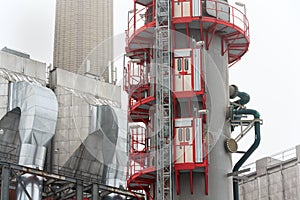 Old a new chimneys at heating plant covered in fog, cloudy winter day, low angle view, energy production, climate change