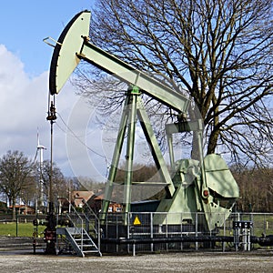 Old and new energy. A nodding donkey and a wind turbine