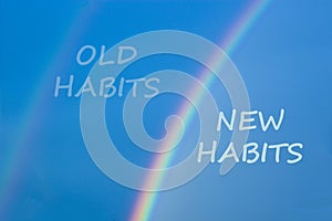 Old or new habits symbol. Rainbow in the blue sky. Words `old habits, new habits`. Peaceful nature. Copy space. Business and old