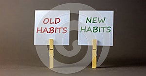 Old or new habits symbol. Wooden clothespins with white sheets of paper. Words `old habits, new habits`. Beautiful grey backgrou