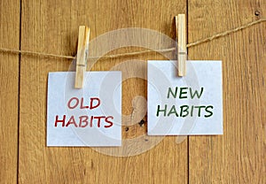 Old or new habits symbol. Wooden clothespins with white sheets of paper. Words `old habits, new habits`. Beautiful wooden