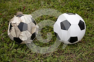 Old and new soccer ball Football on green grass