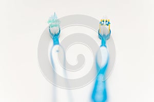 Old and new toothbrushes on a white background. Prevention of caries. Teeth care. Softfocus