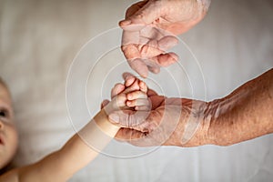 Old and newborn hands touching each other. hands closeup. Mom and her Child. Happy Family concept. Beautiful conceptual image of