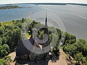 Old nice catholic church. long Pier breakwater cutwater in lake or sea. Summer