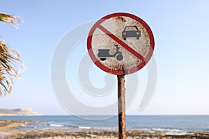 Old No cars no motorbikes sign on the beach and blue sky background on sunny day