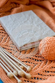 Old notebook for records, ball of yarn and knitting needles