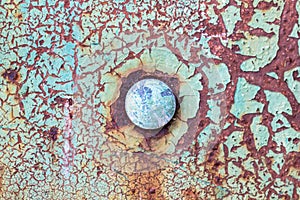 Old obsolete rusty metal surface with round rivet in the middle