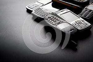 Old and obsoleted cellphones on black background