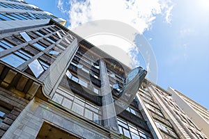 Old office building facade with clock and cloudy sky