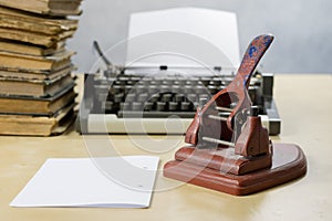 Old office paper punch on a wooden table. Office accessories on