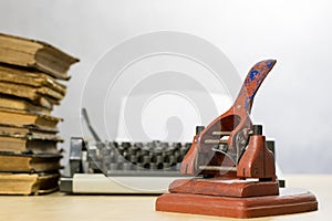 Old office paper punch on a wooden table. Office accessories on