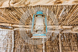 A old oil lamp hanging on the ceiling of wood house of the Heritage folk village in Abu Dhabi, United Arab Emirates