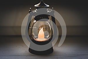 Old oil lamp in the night. Vintage lantern on black background. Decorative lamp in evening. Blackout in Ukraine. Home interior.