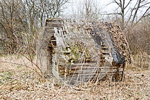 Old old dilapidated little wooden abandoned ruined rickety broken village house of beams, logs and sticks in the wilderness