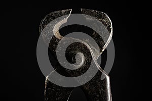 Old nail puller tool on black background