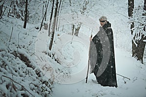 Old one eyed man in a forest with snow