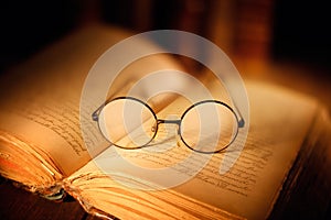 Old open book with glasses