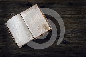 Old open book without text on a wooden table