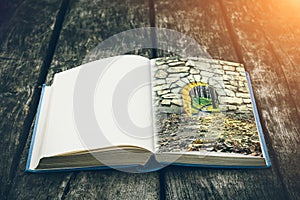 Old open book on a wooden table. Vintage composition. Ancient library. Antique literature. Medieval and mystical background.