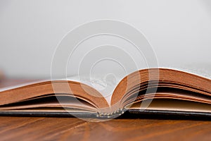 Old open book on a wooden table. White background. Copy space