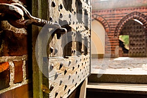 Old open wooden door with carved pattern and metal knob in a medieval castle