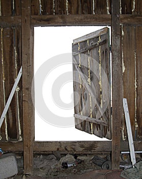 Old open wooden door with empty white space behind. Abandoned attic wooden wall with garbage as a template for backspace