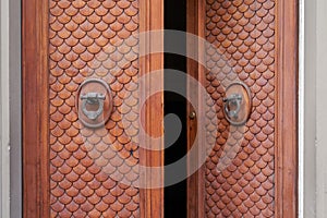 Old opened wooden door with bronze knockers in Florence, Italy