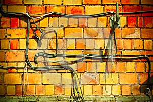 Old orange brick wall. Communication cables