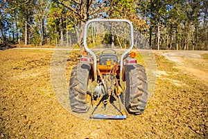 Old orange  farm tractor rear view