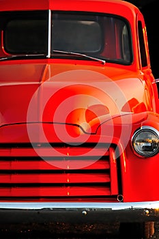 Old orange Ford truck at sunset