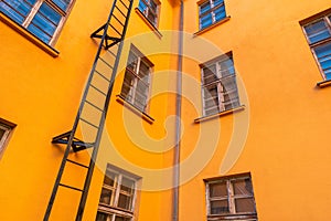 Old orange industrial building with fire escape leading