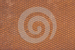 Old, orange, metal plate with diamond shaped grid on it