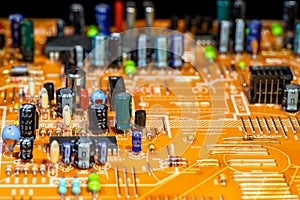 Old orange printed circuit board with multi-colored electronic components