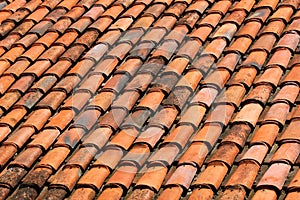 Old orange weathered roof shingles. Dirty stained ceramic tiles