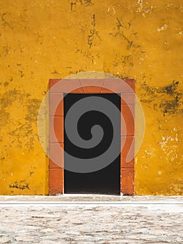 Old orange and yellow doorway of a Spanish-colonial style building in Mexico